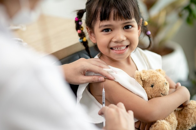 Foto concepto de vacunación doctora vacunando a una niña linda en la clínica