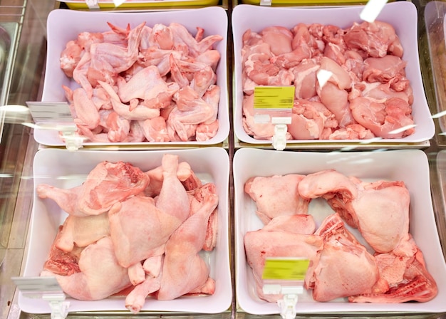 concepto de venta y alimentación - carne de aves de corral en cuencos en los puestos de comestibles