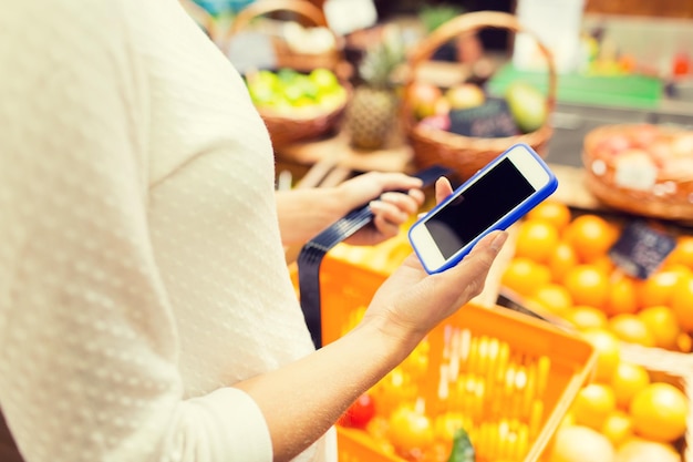 concepto de venta, compras, consumismo y personas - cierre de mujer joven con canasta de alimentos en el mercado