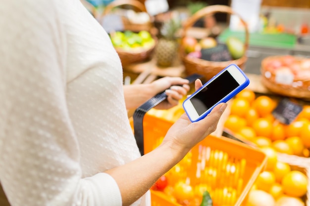 concepto de venta, compras, consumismo y personas - cierre de mujer joven con canasta de alimentos en el mercado