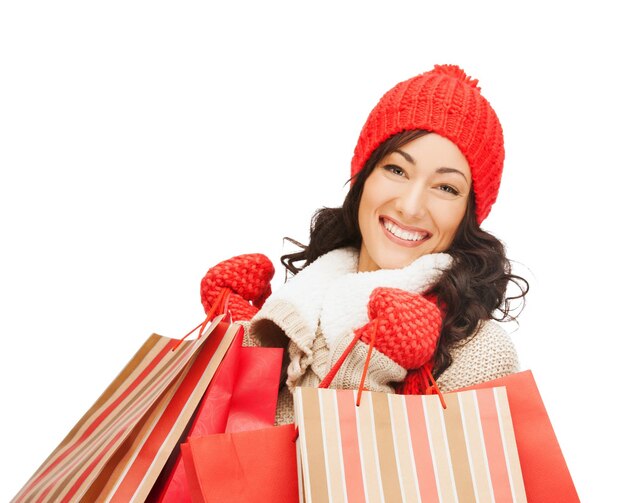 Concepto de venta minorista y venta - mujer feliz en ropa de invierno con bolsas de la compra.