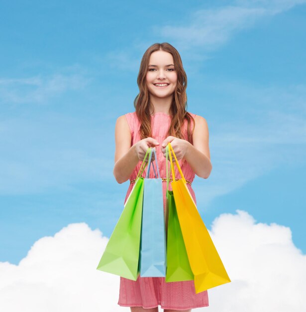 concepto de venta minorista y venta - mujer sonriente vestida con muchas bolsas de compras