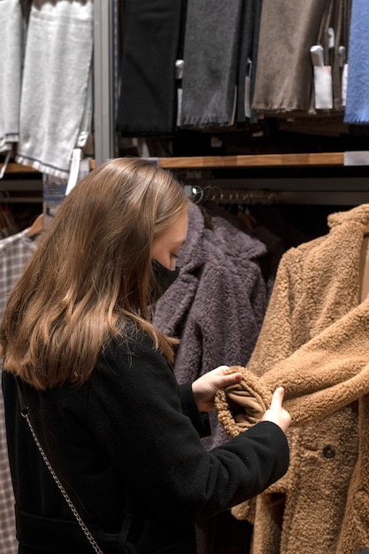 Concepto de venta de viernes negro. Una niña y un joven con compras en el centro comercial. Elige ropa. Probando ropa.