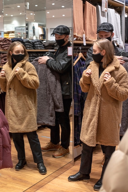 Concepto de venta de viernes negro. Una niña y un joven con compras en el centro comercial. Elige ropa. Probando ropa.