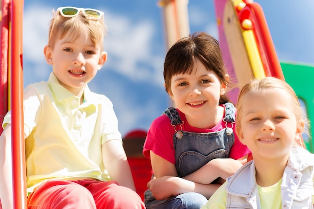 concepto de verano, infancia, ocio, amistad y personas - grupo de niños felices en el parque infantil