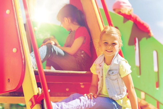 concepto de verano, infancia, ocio, amistad y personas - niños felices en el parque infantil de escalada