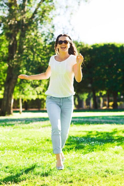 concepto de verano, ocio, vacaciones y personas - joven sonriente con gafas de sol parada en el parque