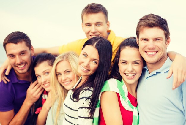 concepto de verano, vacaciones, vacaciones y felicidad - grupo de amigos divirtiéndose en la playa