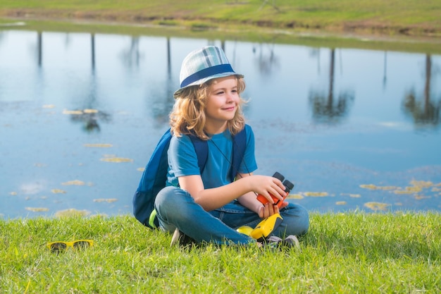 Concepto de viaje y aventura Niño pequeño niño explorador turístico con binoculares en la naturaleza Descubrimiento