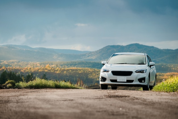 Concepto de viaje por carretera, conducir un automóvil en la temporada de otoño y otoño, hermosas montañas Hills as bac