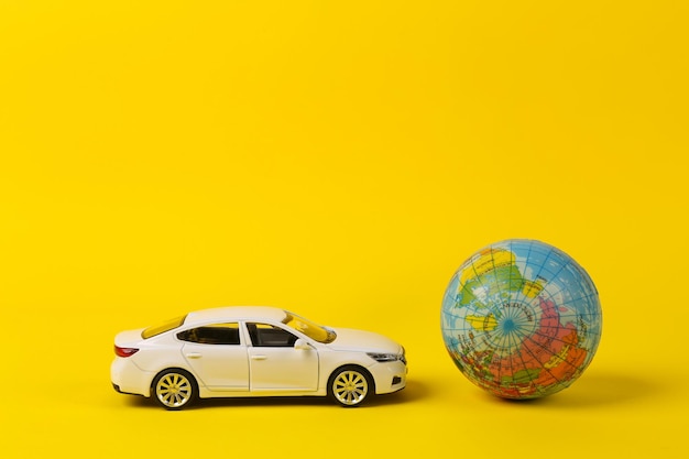 Concepto de viaje en coche Modelo de coche de juguete con globo sobre fondo amarillo