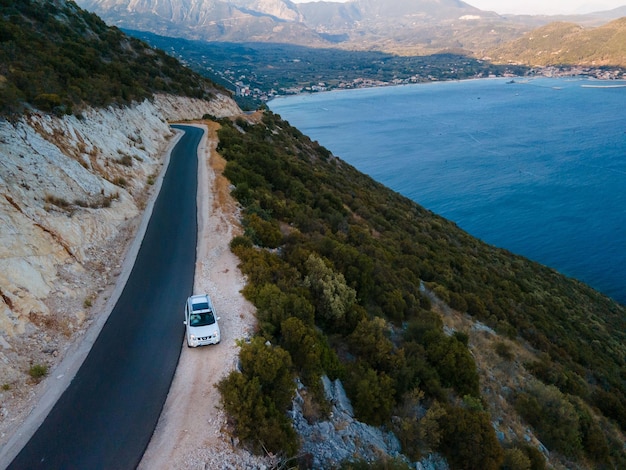 Concepto de viaje en coche moviéndose por carretera en las montañas con vista a la orilla del mar