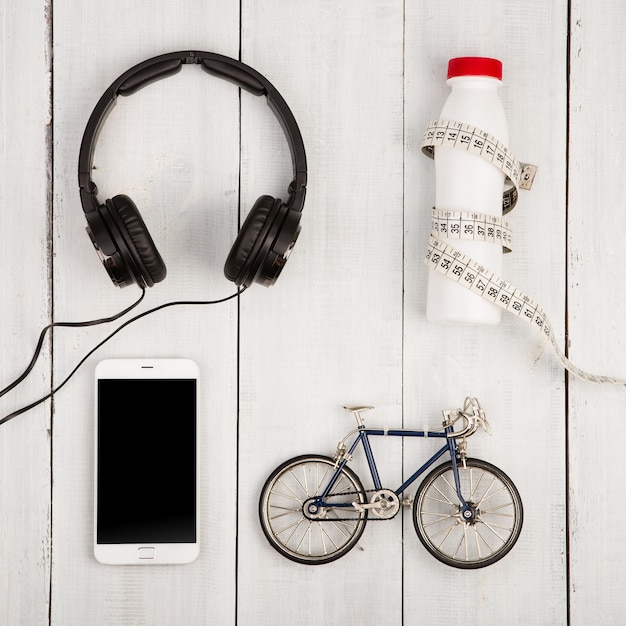 Concepto de viaje y deporte bicicleta modelo auriculares teléfono inteligente botella de agua y cinta centimétrica