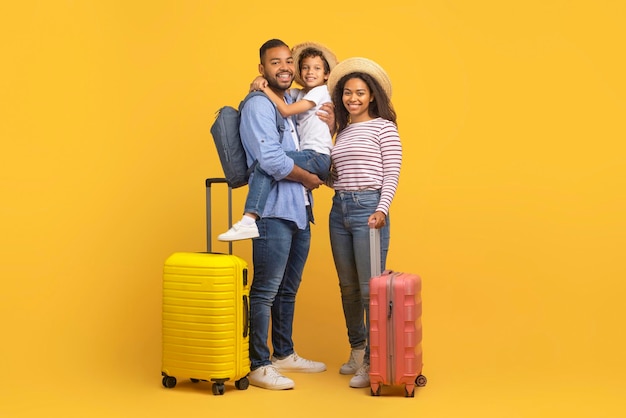 Concepto de viaje familiar padres afroamericanos felices viajando con su hijo pequeño