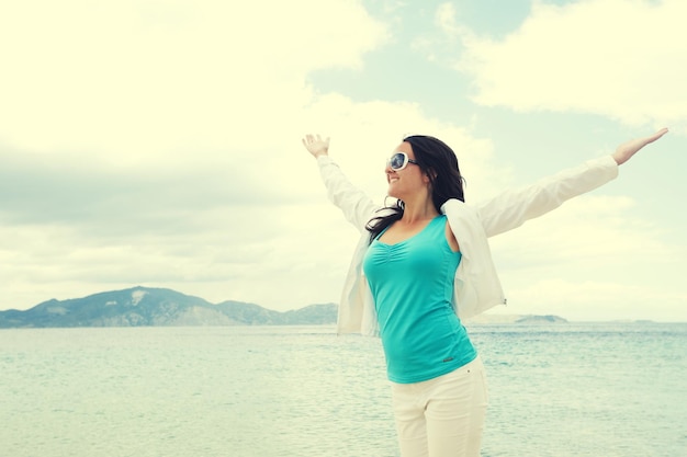 Concepto de viaje niña feliz saltando en la playa vacaciones de verano