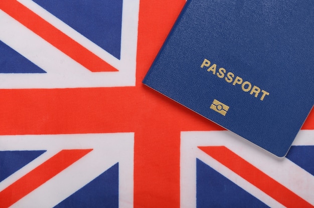 Concepto de viaje. Pasaporte con el telón de fondo de la bandera británica