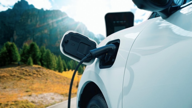 Concepto de viaje progresivo en coche EV en montaña remota con estación de carga