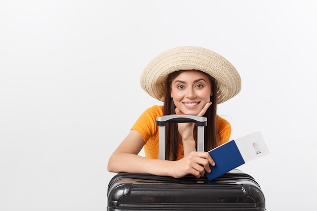 Concepto de viaje. Retrato de estudio de bastante joven con pasaporte y equipaje. Aislado en blanco