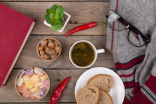 Concepto de viaje taza de té suéter libro anteojos nueces dulces