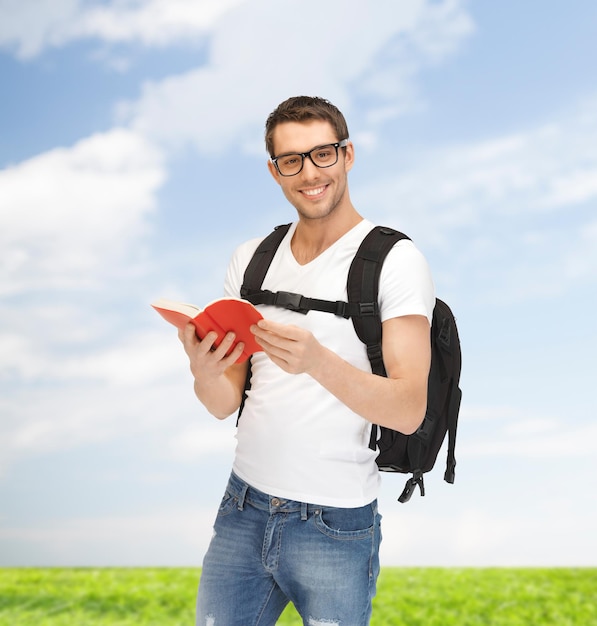 concepto de viaje, vacaciones y educación - estudiante viajero con mochila y libro