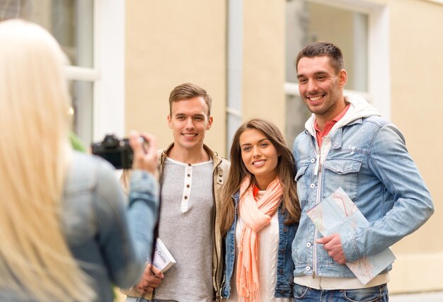 concepto de viaje, vacaciones, tecnología y amistad - chica imaginando un grupo de amigos con mapa y guía de la ciudad en la ciudad