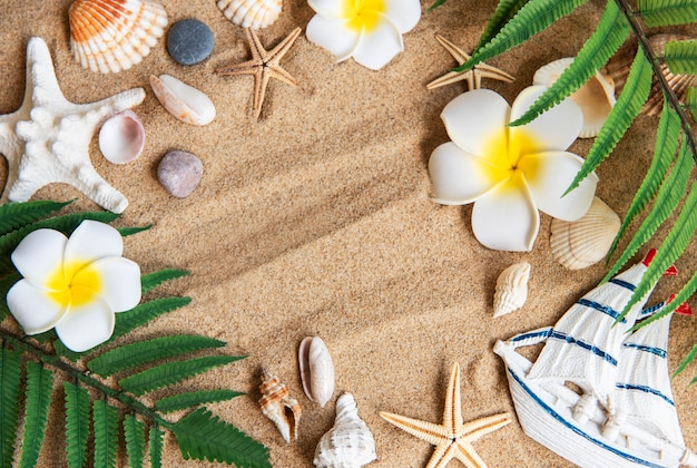 Concepto de viaje de verano con estrellas de pescado y conchas de mar en el fondo de arena