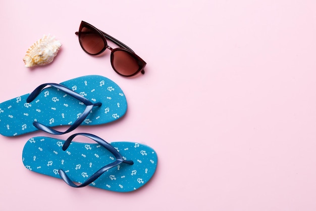 Concepto de viaje de verano Flip flops gafas de sol y estrellas de mar en blanco Vista superior sobre fondo de color