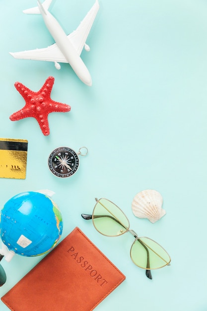 concepto de viaje de viaje de vacaciones. Pasaporte de avión gafas de sol globo tarjeta de crédito de oro sobre fondo azul.