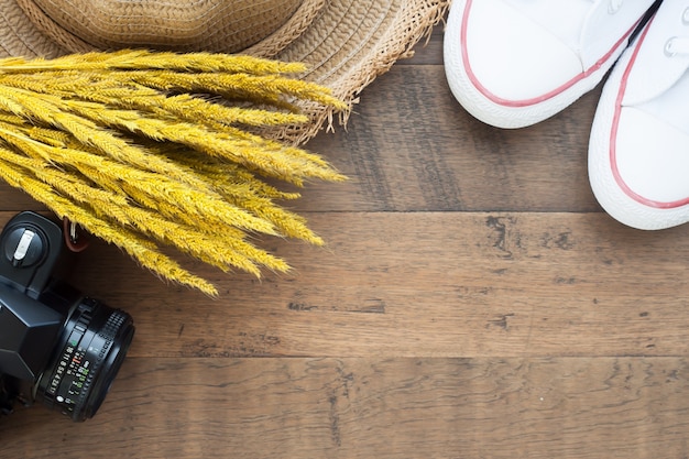 Concepto de viajes de otoño, flores secas, cámara y zapatos sobre fondo de madera