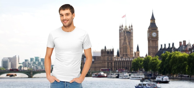 concepto de viajes, turismo y personas - hombre sonriente con una camiseta blanca en blanco sobre el fondo de la ciudad de Londres