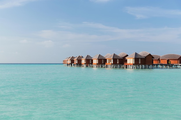 concepto de viajes, turismo, vacaciones y vacaciones de verano - cabañas de bungalows en agua de mar en una playa exótica