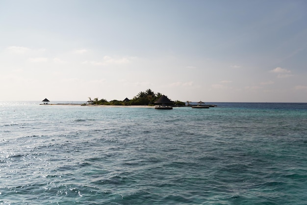 concepto de viajes, turismo, vacaciones y vacaciones de verano - playa de la isla de maldivas con palmera y villa