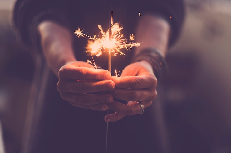 Foto concepto de vida nocturna de fiesta y víspera de año nuevo 2020 - cerca de las manos de la gente con bengalas de fuego rojo para celebrar la noche y el nuevo comienzo - filtro de colores cálidos