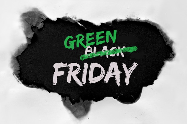 Concepto de viernes verde con agujero quemado en papel blanco. Texto "Black Friday Sale" con la palabra "Black" tachada para ser reemplazada por "Green" en su lugar.