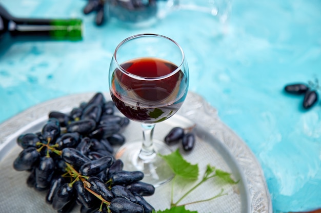 Concepto de vino tinto con botella, vidrio y uvas