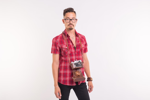 Concepto vintage, fotógrafo y personas - hombre guapo con cámara retro sobre fondo blanco con espacio de copia.