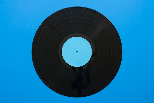 Concepto vintage de música con vinilo sobre fondo azul
