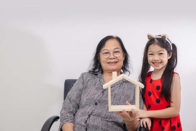 Concepto de vivienda familiar Abuela e hijo con modelo de casa