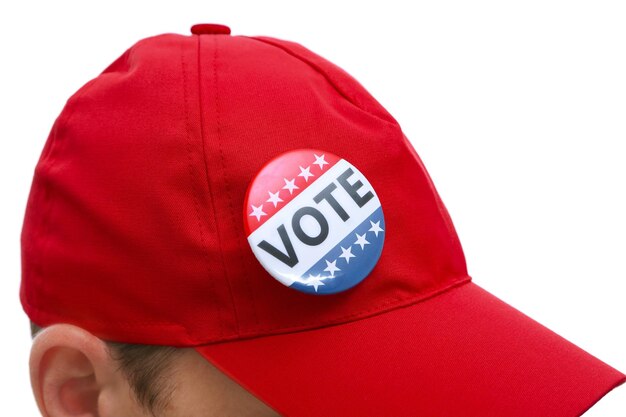 Foto concepto de los votos estadounidenses insignia de votación pegada en la gorra roja de cerca