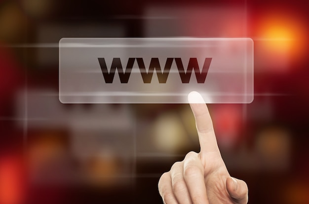 Concepto de WWW y mano masculina presionando un botón Web sobre fondo abstracto borroso