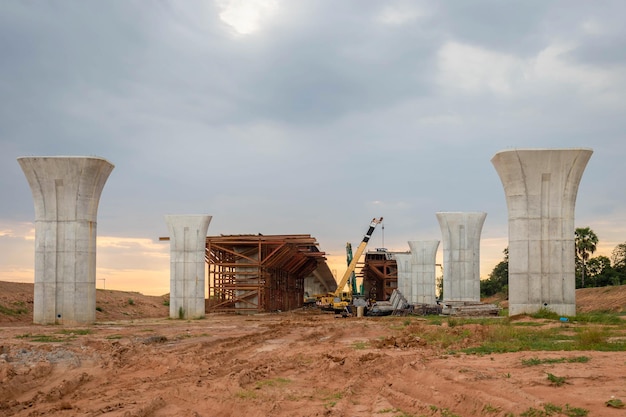 Conceptos de construcción de infraestructura Construcción de línea de autopista en progreso con infraestructura pesada Sitio de construcción de puente con marco de hormigón prefabricado de elevación de grúa