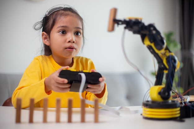 Conceptos de educación STEM Estudiantes asiáticos aprenden en casa codificando brazos robóticos en STEM matemáticas ingeniería ciencia tecnología código informático en robótica para niños conceptos