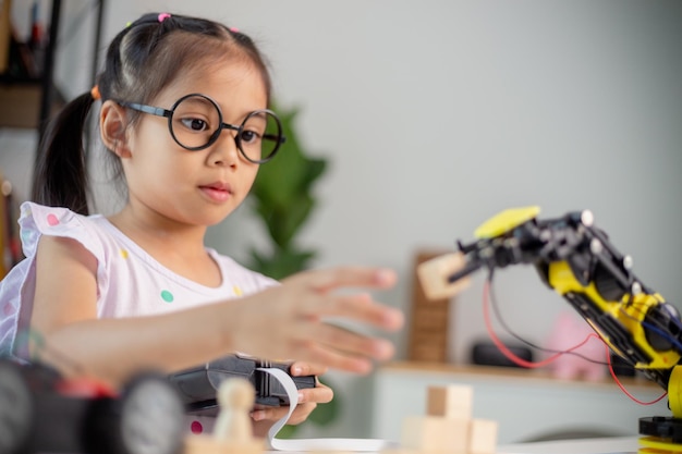 Conceptos de educación STEM Estudiantes asiáticos aprenden en casa codificando brazos robóticos en STEM matemáticas ingeniería ciencia tecnología código informático en robótica para niños conceptos