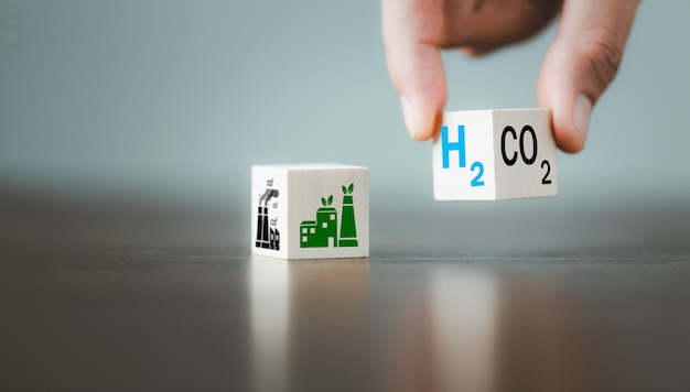 Conceptos de energía alternativa de carbono libre y cambio climático global Voltear a mano bloques de cubos de madera con CO2 Cambio de dióxido de carbono a H2 Texto de hidrógeno en el fondo de la tabla Energía sostenible del automóvil