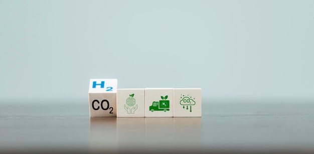 Conceptos de energía alternativa de carbono libre y cambio climático global Voltear a mano bloques de cubos de madera con CO2 Cambio de dióxido de carbono a H2 Texto de hidrógeno en el fondo de la tabla Energía sostenible del automóvil