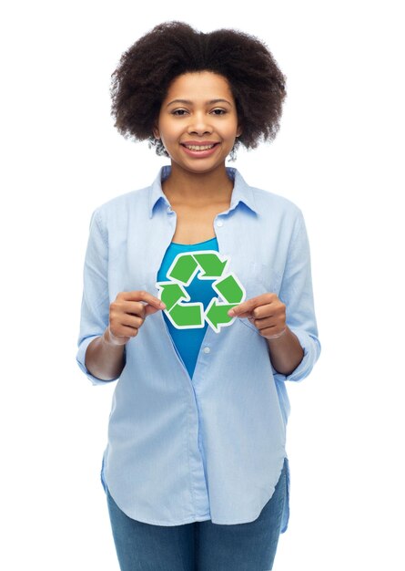 Foto conceptos de personas, conservación, ecología y medio ambiente: joven afroamericana feliz con símbolo de reciclaje sobre blanco