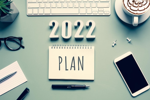 Conceptos de plan de año nuevo 2022 con texto en bloc de notas y accesorios de oficina.Gestión empresarial,Inspiración para ideas de éxito