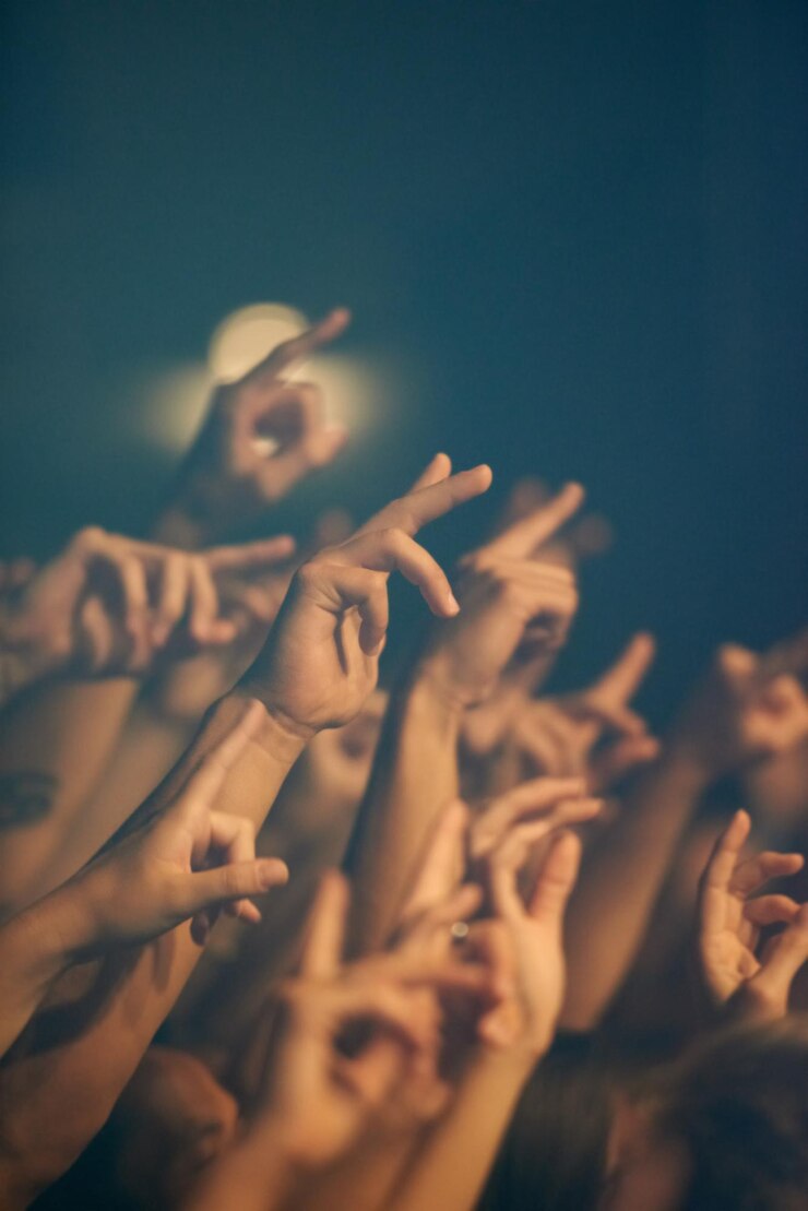 Foto concerto de rock, mãos e festival de música com pessoas, evento e festa com diversão e entretenimento, energia de liberdade ou multidão gritando de excitação e social com o público ou grupo com apresentação.