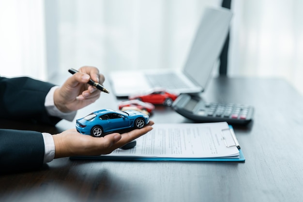 Un concesionario de automóviles está explicando a los clientes acerca de los préstamos con seguro de alquiler de automóviles La compra de un automóvil