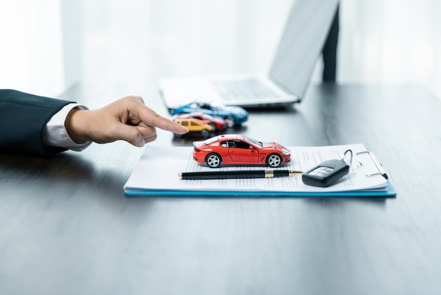 Un concesionario de automóviles está explicando a los clientes acerca de los préstamos con seguro de alquiler de automóviles La compra de un automóvil